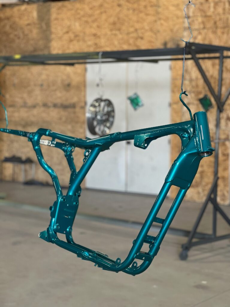 A blue motorcycle frame hanging from the ceiling.