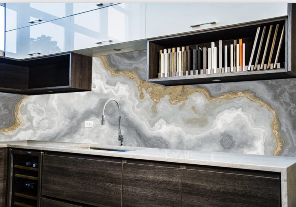 A kitchen with marble countertops and a book shelf.