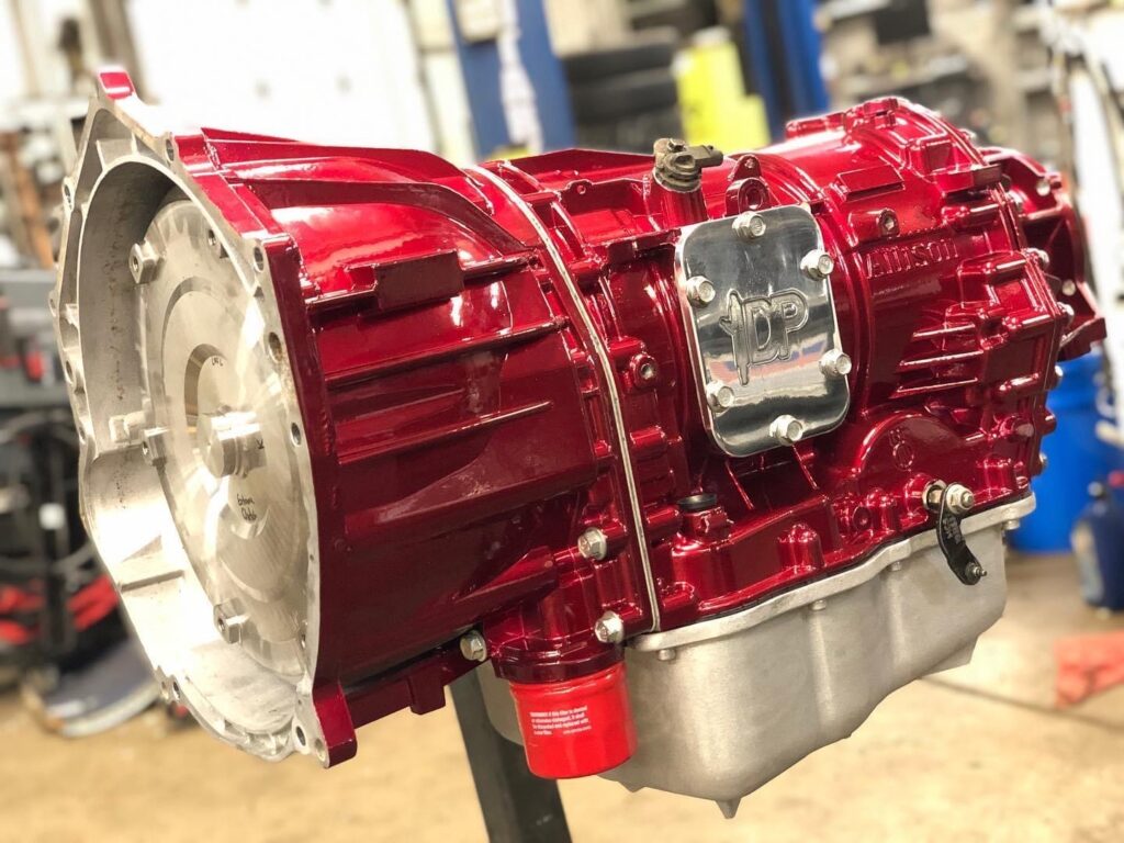 A red car engine sitting on top of a stand.